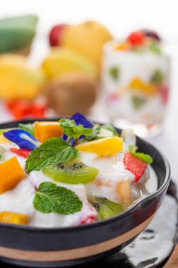 Ahşap zemindeki bir kasede meyve salatası. Seçici odak.