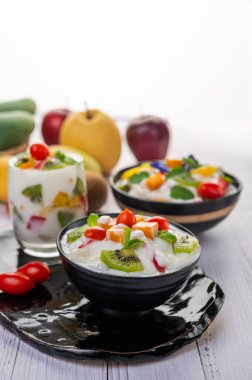 Ahşap zemindeki bir kasede meyve salatası. Seçici odak.
