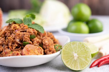 Limon, acı biber ve meze içeren beyaz bir tabakta baharatlı domuz pirzolası. Seçici odak.