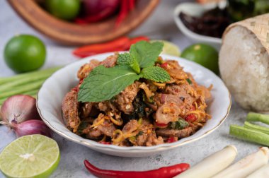 Limon, acı biber ve meze içeren beyaz bir tabakta baharatlı domuz pirzolası. Seçici odak.