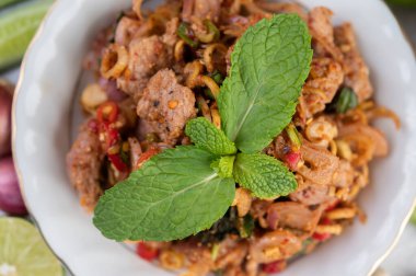 Limon, acı biber ve meze içeren beyaz bir tabakta baharatlı domuz pirzolası. Seçici odak.