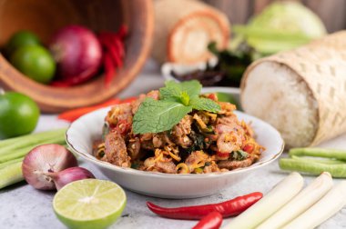 Limon, acı biber ve meze içeren beyaz bir tabakta baharatlı domuz pirzolası. Seçici odak.