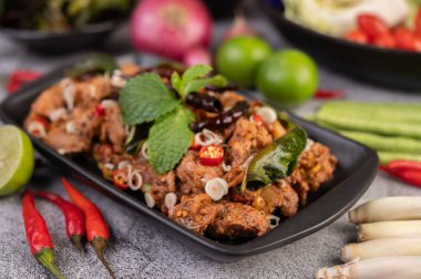 Limon, acı biber ve meze içeren siyah bir tabakta baharatlı domuz pirzolası. Seçici odak.