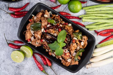 Limon, acı biber ve meze içeren siyah bir tabakta baharatlı domuz pirzolası. Seçici odak.