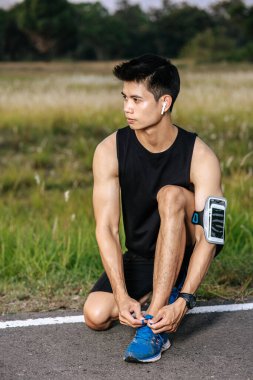 O adam spor yapmak için ayakkabı bağcığı bağladı. Seçici odak.