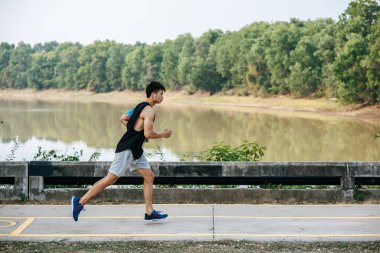 Erkekler köprüde yolda koşarak egzersiz yaparlar..
