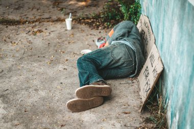 Dilenciler kirli giysilerle sokağın kendi tarafında yatıyorlardı..