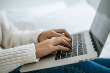 Dizüstü bilgisayara yerleştirilmiş bir kadın eli. Seçici odak.