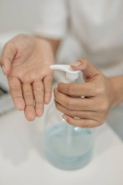 Ellerini yıkamak için jel ütüleyen beyaz gömlekli kadınlar..