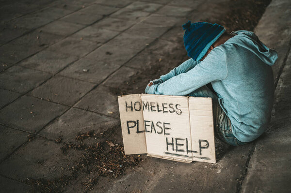 The beggars sit under the bridge with a homeless message. Please help.