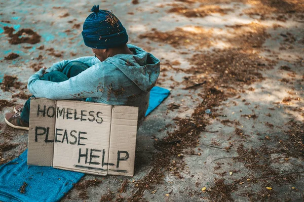 ホームレスのメッセージが書かれた通りに座っている乞食を助けてください — ストック写真