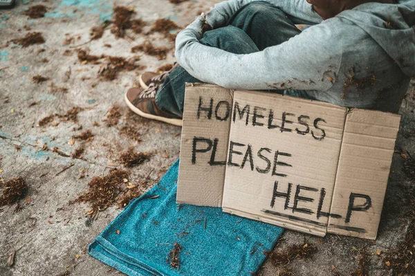 ホームレスのメッセージが書かれた通りに座っている乞食を助けてください — ストック写真