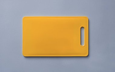 Sarı plastik kesme tahtası mavi arka plan üzerinde renkli, top vie