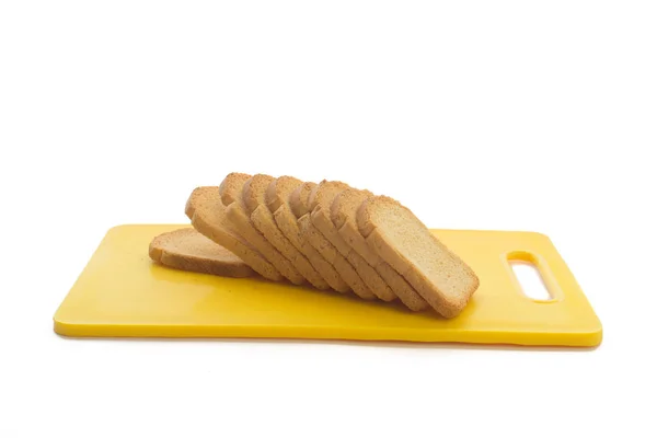 Crispy roti panggang rusk di atas plastik memotong papan terisolasi pada putih . — Stok Foto