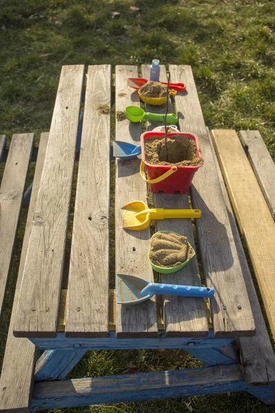 Uma mesa servida com brinquedos de areia de criança em um parque . — Fotografia de Stock