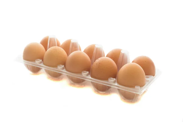 Vista de cerca de los huevos de gallina crudos en la caja de huevos transparente isolat — Foto de Stock