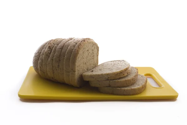 Frisch gebackenes Vollkornbrot und geschnittenes Brot auf Plastikschneidebrett isoliert auf weißem Hintergrund. — Stockfoto