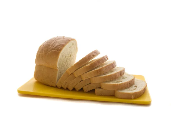 Pane fatto in casa al forno e pane affettato sul tagliere giallo di plastica . — Foto Stock
