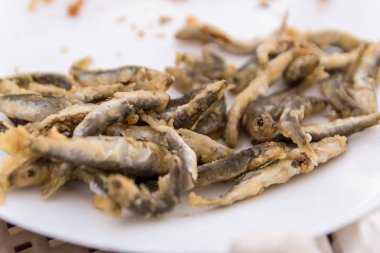 Beyaz masa üzerinde beyaz tabakta kızarmış sprat bir restoranda servis edilir. Seçici odaklama.