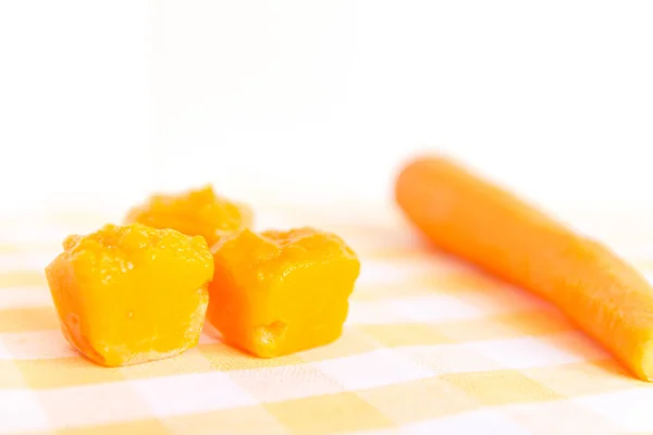 Готовлю детское питание, домашнее. Замороженная морковь, сделанная как кубик льда на скатерти. Концепция здорового питания детей. Селективный фокус . — стоковое фото