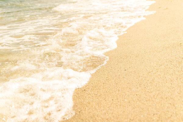 The sea waves are washing the sandy beach. Selective focus.
