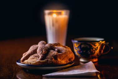 Pan de Muerto y veladora encendida 