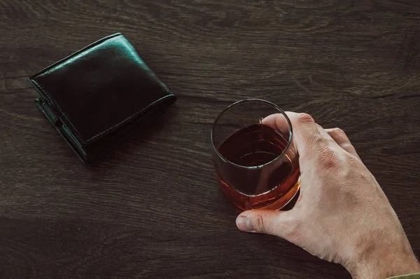 A man holding a glass of whiskey. Male hands holding a glass cup — Stock Photo, Image