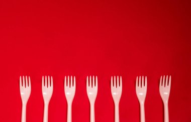 kırmızı bir arka plan üzerinde plastik tek çatal gereçleri mutfak eşyaları