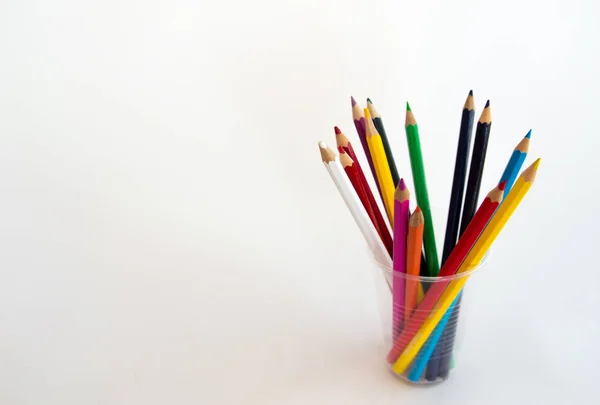 Colored wooden pencils for drawing in a glass stand on a white b — Stock Photo, Image