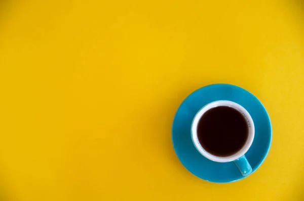 La taza de café azul está sobre un fondo amarillo. Descanso matutino —  Fotos de Stock