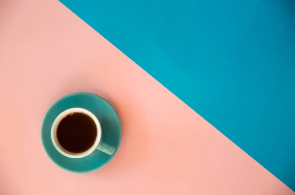 Una taza de café azul se apoya sobre un fondo rosa y azul. Morni. —  Fotos de Stock
