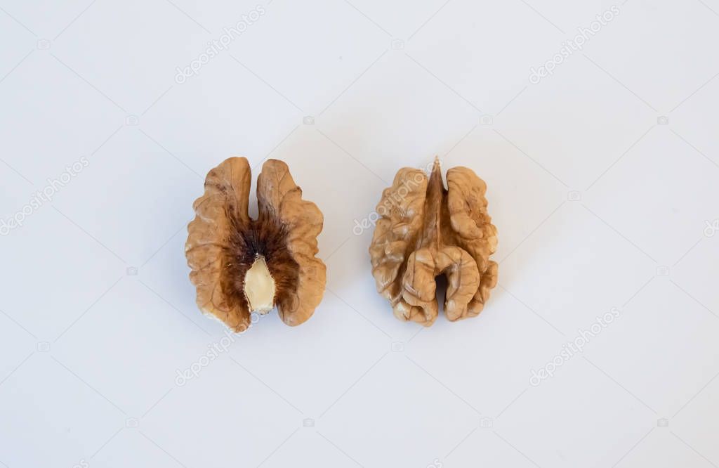 two halves of peeled walnut on a white background close-up