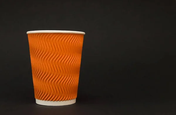 Papier opnieuw plaatsen oranje koffie kopje staat op een zwarte achtergrond — Stockfoto