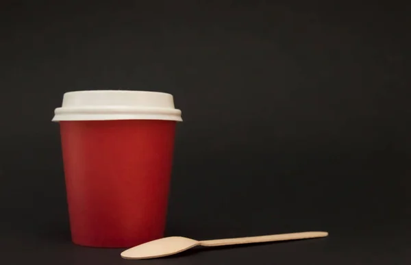 Taza de papel rojo con una tapa para los puestos de café sobre un fondo negro —  Fotos de Stock