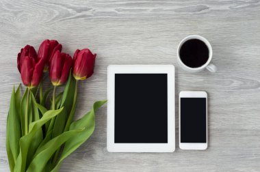 Beyaz telefonlu beyaz tablet beyaz ahşap bir masanın üzerinde.