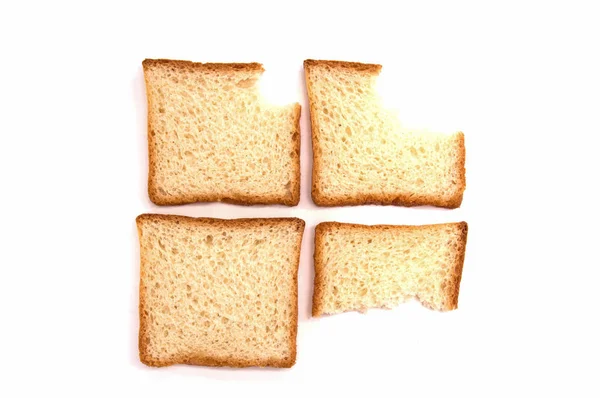 Four bites of toast bread on white background — Stock Photo, Image