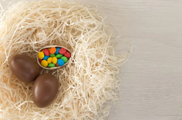 Easter. Chocolate eggs with multicolored candies lie in a nest o