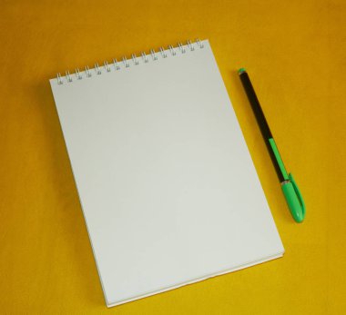 Defter notları bir defter için sarı bir arka plan üzerinde kalem ile. Ofis okul ve ofis için.