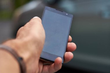 Akıllı telefonu tutan bir adamın eli.