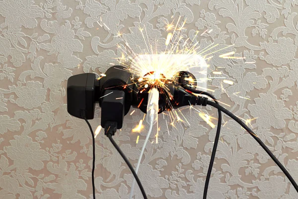 Aşırı yüklenmiş soket, kıvılcım. Elektrik şoku tehlikesi, yangın. Kablo, fiş, ateş.