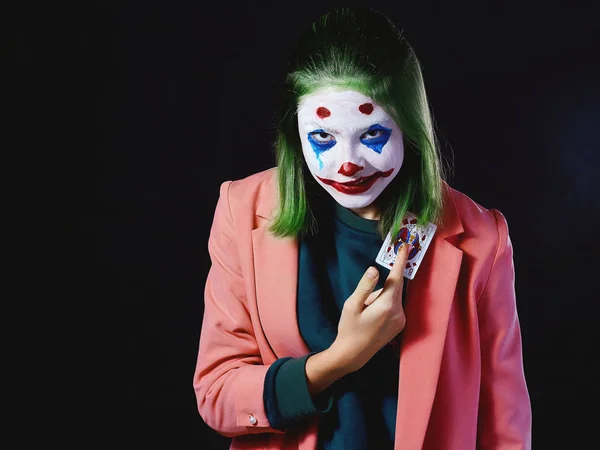 Image of a clown for halloween girl in a Joker costume on a dark background, photo shoot in the Studio. — Stock Photo, Image