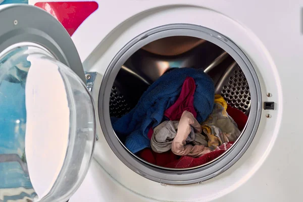 Vuil linnen, doek in de wasmachine. Wasserij, netheid, ronde deur. — Stockfoto