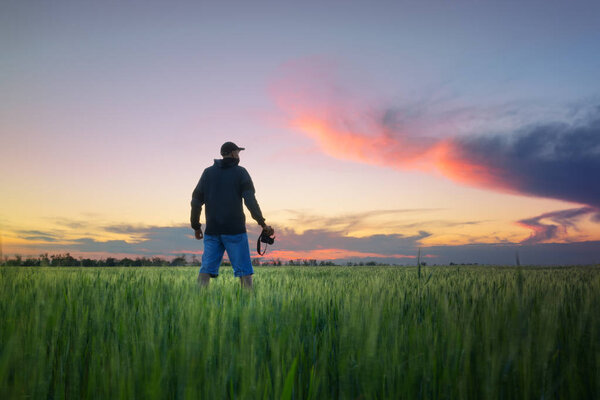 man on a wheat field / photographer in search of spring sunset plot