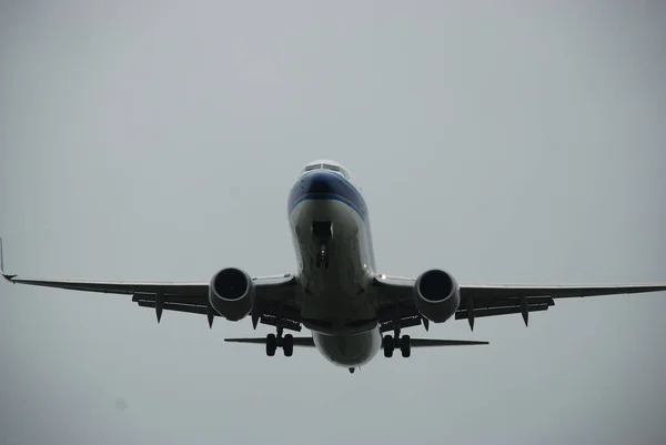 Airplane on descending, wheels out, low hight, on the way to the runway strip on the rainy day