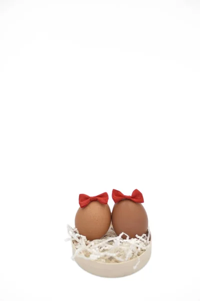 Beyaz crumped kağıt üzerinde birlikte iki kahverengi yumurta keser ile kırmızı yay