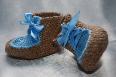 Yün ve mavi dantel ile yapılan bir bebek için küçük ayakkabı