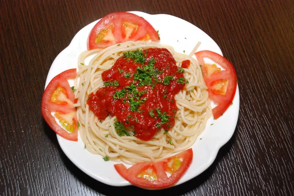 Паста с помидорами на белой тарелке — стоковое фото