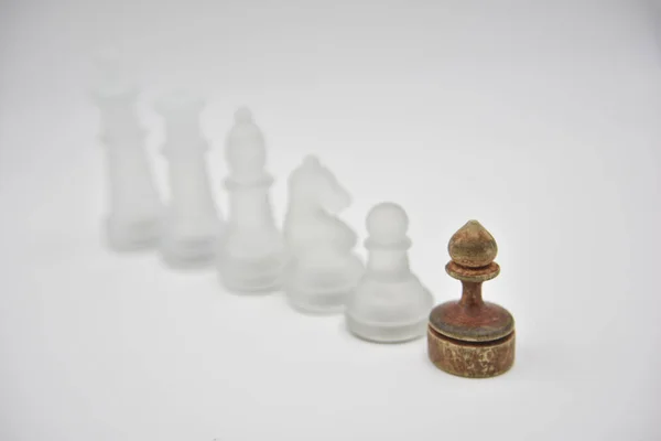 Glass chess figures behind wooden ponce — Stock Photo, Image