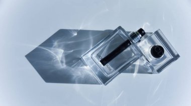 Bir şişe Christian Dior Homme parfümü. Güneş ışığı geçiyor ve ışık kırılması ve ışık efektleri yapıyor. Editör moda konsepti.