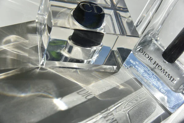 Bir şişe Christian Dior Homme parfümü. Güneş ışığı geçiyor ve ışık kırılması ve ışık efektleri yapıyor. Editör moda konsepti.